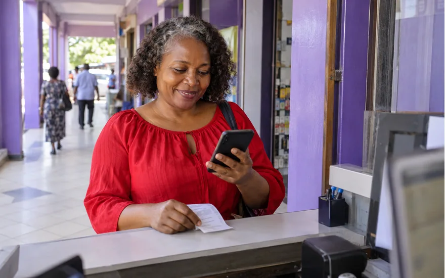 Wasafi Bet Tigo Pesa and Mixx record checking illustrated by an adult comparing a transfer receipt with her phone