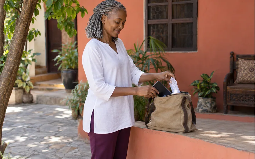 Adult Tanzania reader setting aside a phone and folded sports coupon before taking a break